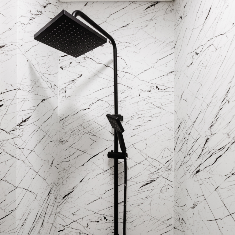 Douche avec covering étanche façon marbre Pommeau de douche noir monté sur un mur avec covering marbrés blancs, dans région Lyonnaise lyon ou nord isere